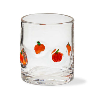 Clear glass tumbler with hand-painted orange pumpkins on a white background