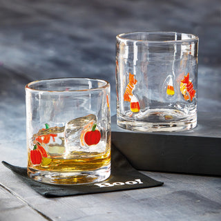 Two glass tumblers with Halloween-themed designs on a dark surface.