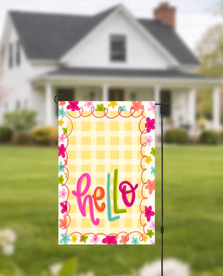 Colorful 'hello' garden flag with a house in the background