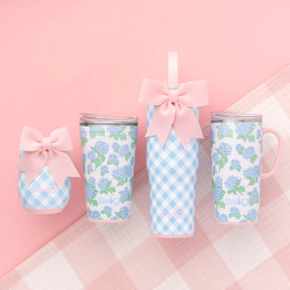 Set of tumblers with floral and checkered patterns on a pink background