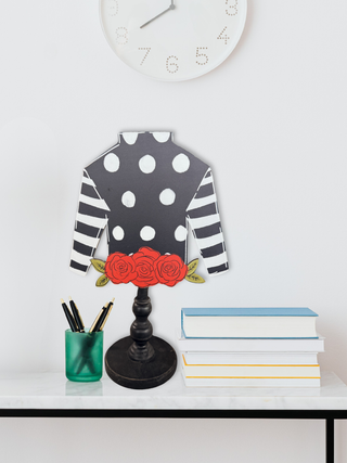 Decorative jockey shirt lamp with polka dots and roses on a white surface.