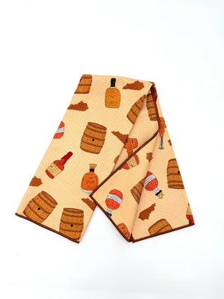 Two folded towels with bourbon bottle and barrel pattern on a white background