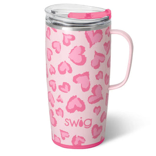 A pink travel tumbler with a matching pink handle and clear lid, decorated with a pink heart pattern and the brand name 'swig' printed near the bottom.