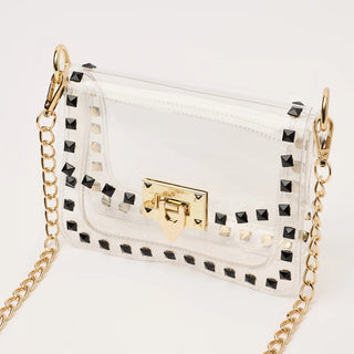 White handbag with gold chain and black studs on a white background