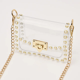 White handbag with gold chain strap and studded details on a white background
