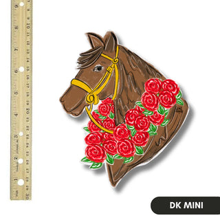 Decorative horse head with red roses and a yellow bridle next to a ruler on a white background