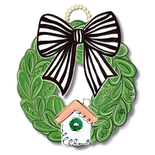 Decorative wreath with a black and white bow and a small house with a green flower on a white background.