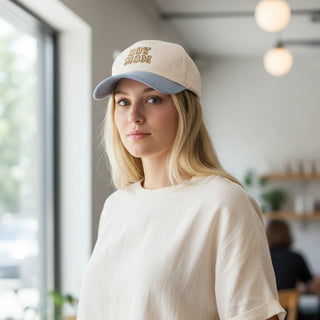 Woman wearing a cap with 'Boy Mom' text in an indoor setting