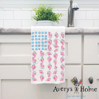 Decorative towel with strawberry pattern hanging on a kitchen rack, branded 'Avery's Home'.