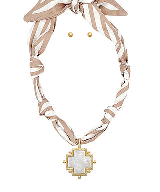 Necklace with cross pendant and matching earrings on a white background