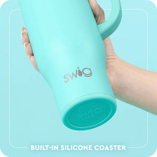 Mint green mug with 'swig' branding held by a hand against a light blue background.