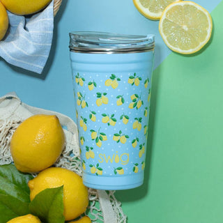 Blue tumbler with lemon pattern and 'Swig' branding surrounded by lemons on a green and blue background