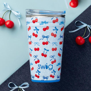 Tumbler with cherry and bow pattern on a blue background, featuring the brand 'swig'.