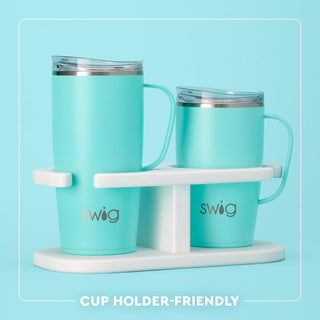Two turquoise mugs with a white stand on a light blue background, featuring the Swig brand.
