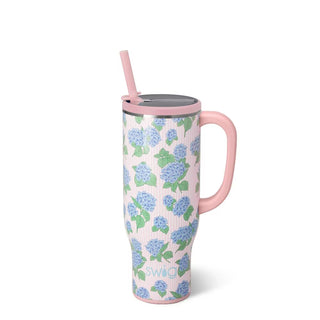 Floral-patterned tumbler with pink handle and straw on a white background