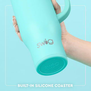 Turquoise swig tumbler held by a hand with 'swig' branding on a light blue background.