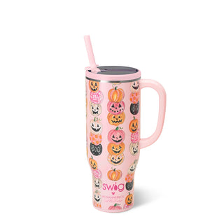 A pink handled travel tumbler with a lid and straw, decorated with a pattern of jack-o'-lanterns and the text 'BOO' and 'swig'.