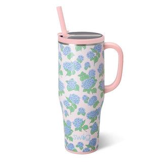 Floral-patterned mug with pink handle and straw on a white background