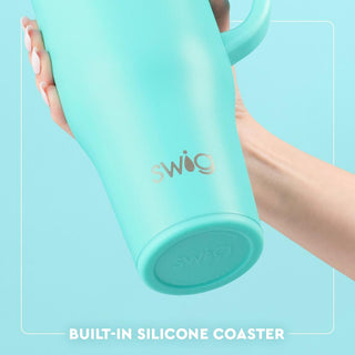 Turquoise tumbler with 'Swig' branding held by a hand on a light blue background