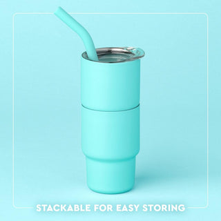 Turquoise tumbler with a straw on a light blue background