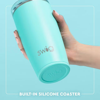 Turquoise tumbler with 'swig' branding held by a hand against a light blue background