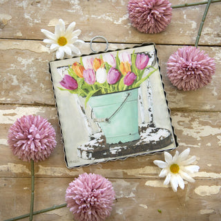Decorative item with a bucket of flowers on a wooden surface with decorative flowers.