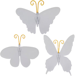 Three white butterfly decorations with yellow stems on a white background