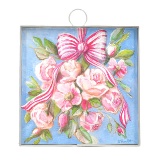 Decorative wall art with pink roses and a bow on a blue background