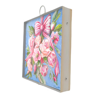 Decorative box with floral design and pink ribbon on a white background