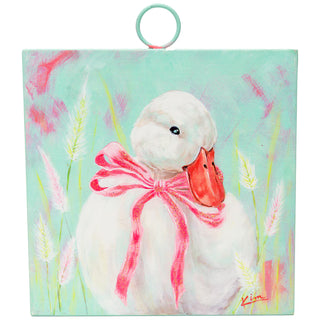 Painting of a duck with a pink bow in a field with watercolor effects