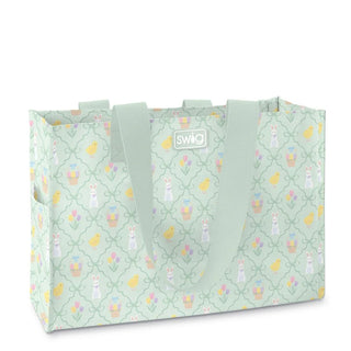 A reusable tote bag with a light mint green background, featuring a repeating Easter-themed pattern of bunnies, chicks, and baskets, with matching mint green handles and a central SWO brand label.