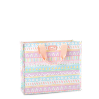 A pastel-colored Swag gift bag featuring horizontal stripes of bunnies, carrots, and flowers in pink, blue, yellow, and white, with peach-colored handles and a Swag logo on the front.
