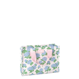 Floral-patterned bag with pink handles on a white background