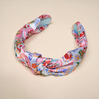 Colorful floral and animal print headband on a beige background