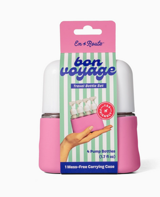 Pink travel bottle set with 'bon voyage' packaging on a white background