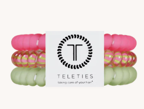 Pink and green hair ties with a Teleties branded card on a white background