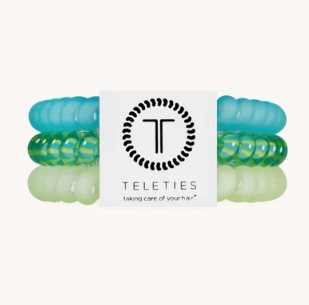 Set of green and blue hair ties with a Teleties branded card on a white background