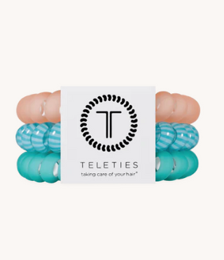 Turquoise hair ties with a Teleties branded card on a white background