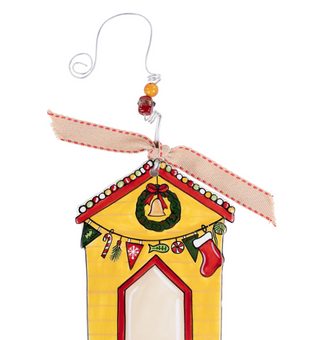 Decorative Christmas house ornament with a wreath, bell, and candy-themed decorations on a white background.