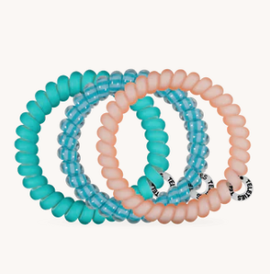 Set of three turquoise and pink spiral hair ties on a white background