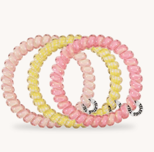 Set of three pink and yellow beaded bracelets on a white background