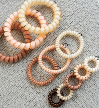 Set of beaded hair ties in various colors on a textured surface