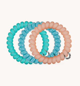 Set of three turquoise and pink hair ties on a white background