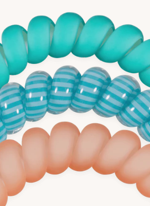 Turquoise and peach spiral hair ties on a white background
