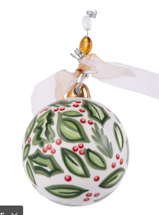 Decorative Christmas ornament with green leaves and red berries on a white background