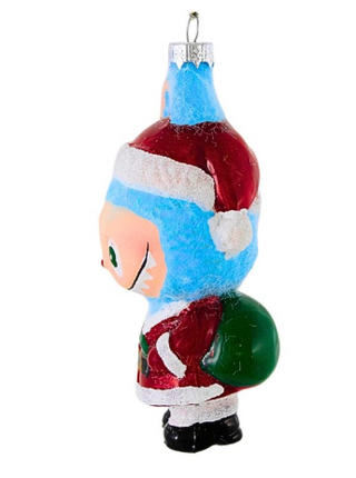 Decorative glass ornament of a character in a Santa hat and red outfit with a green ball, on a white background.