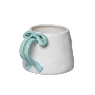White ceramic mug with a light blue knot design on a white background
