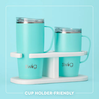 Two turquoise mugs with a white stand on a light blue background, featuring the Swig brand.