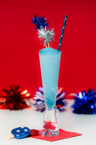 Blue cocktail with festive garnish on a red background