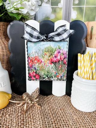 Decorative box with floral design on a table with flowers and paper straws.